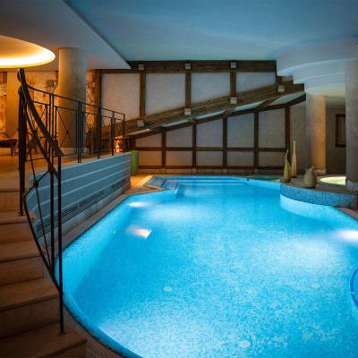 Piscina interna elegante, atmosfera rilassante con luci soffuse e design moderno.