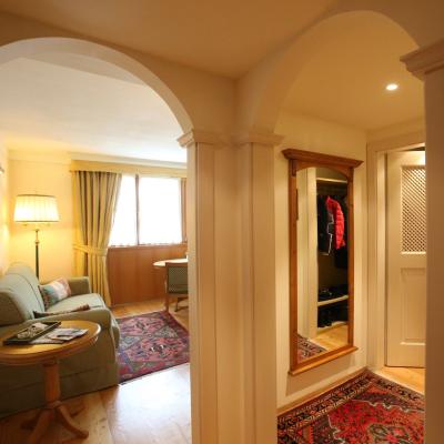 Accogliente salotto con archi, tappeti colorati, divano e luce calda. Atmosfera intima e rilassante.