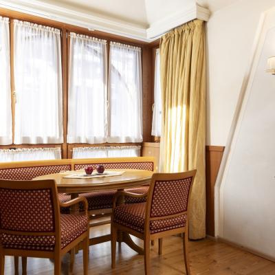 Accogliente angolo pranzo con sedie imbottite, tavolo in legno e luce calda.
