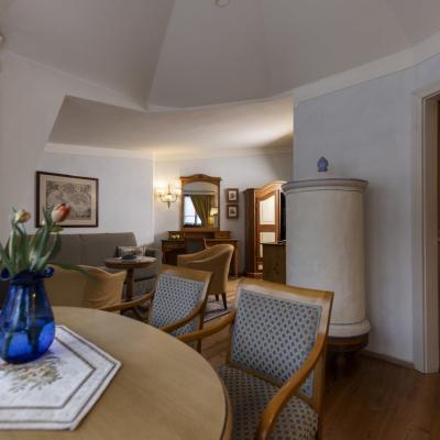 Elegante soggiorno con fiori, mobili classici e luce calda, atmosfera accogliente e raffinata.