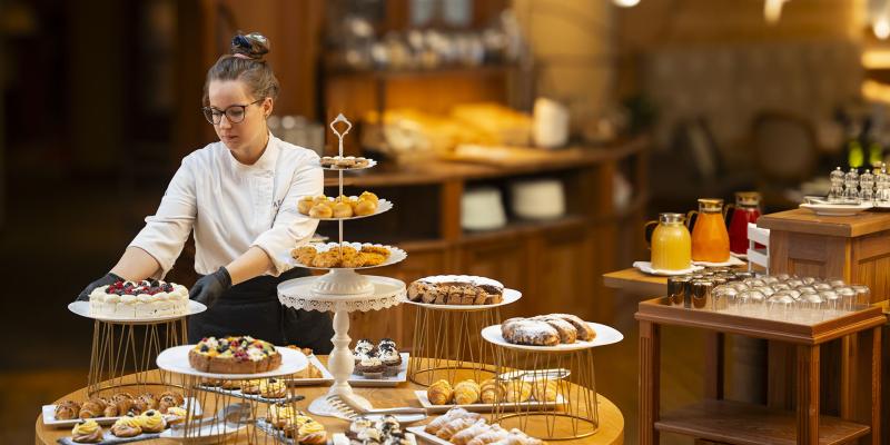 Chef prepara un buffet di dolci colorati, creando un'atmosfera calda e accogliente.
