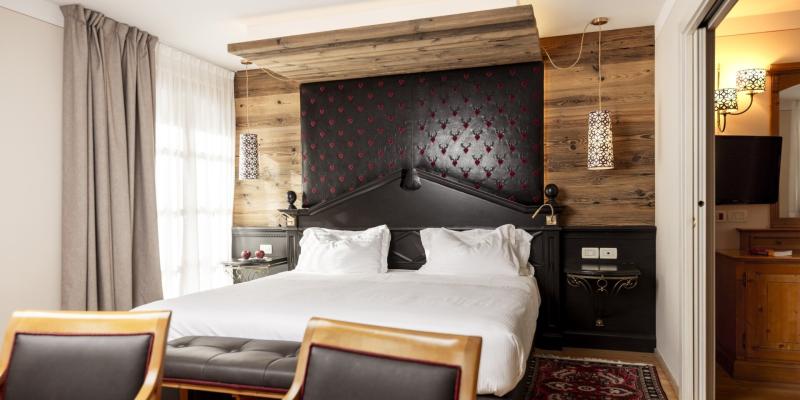 Camera accogliente e lussuosa con letto elegante, legno caldo e lampade decorative.